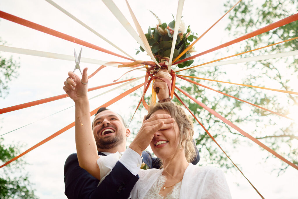 Le marié cache les yeux de la mariée pendant le jeu des rubans.