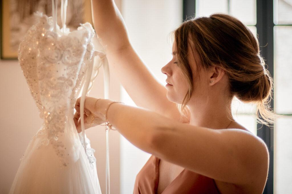 La demoiselle d'honneur prépare la robe de la mariée.