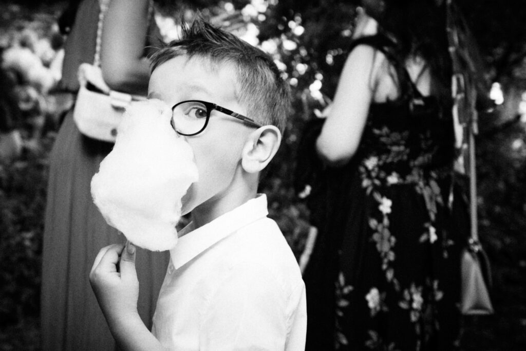 Un jeune garçon mange une barbe à papa.